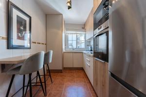 eine Küche mit Tisch, Stühlen und Kühlschrank in der Unterkunft Oasis Mijas Centro in Mijas + 12 Fotos