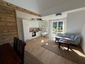 a living room with a blue couch and a kitchen at Landhausloft in Bermatingen
