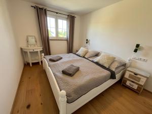 a bedroom with a large white bed with a window at Landhausloft in Bermatingen