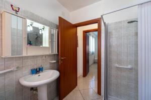 a bathroom with a sink and a mirror and a shower at Casa Flavia in Nebida +7 photos