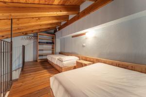 a bedroom with two beds and wooden ceilings at Civico 5 in Marmora
