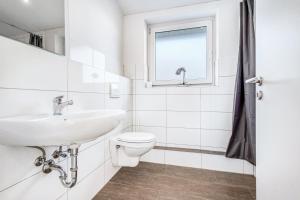 a white bathroom with a sink and a toilet at Haus Primavera in Bad Bentheim +23 photos