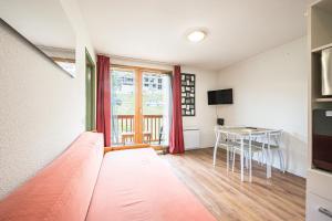 a bedroom with a bed and a desk and a window at Appartement 'Bds1 37' 5 Couchage in Saint-François-Longchamp