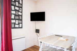 a dining room with a table and a tv on a wall at Appartement 'Bds1 37' 5 Couchage in Saint-François-Longchamp
