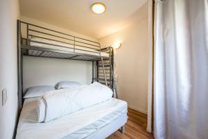 a bedroom with two bunk beds with white sheets at Appartement 'Bds1 37' 5 Couchage in Saint-François-Longchamp