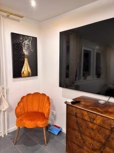 an orange chair sitting in a room with a dresser at Ferienhaus Lopezan House, Living in Hornberg
