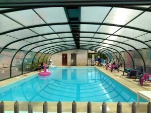 a large swimming pool with a glass ceiling at Domaine de Chante-Oiseau - 34 pers in Theil-Rabier