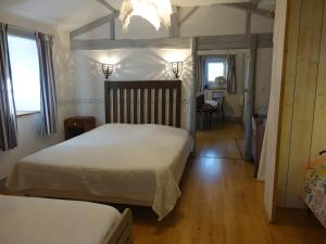 a bedroom with two beds and a table and a chair at Domaine de Chante-Oiseau - 34 pers in Theil-Rabier