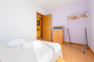 a bedroom with a white bed and a dresser at Dorada Apartment Mar in Calafell +16 photos