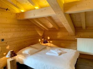 a bedroom with a bed in a wooden room at Chez Gilles chalet haute cimes in Châtel +12 photos