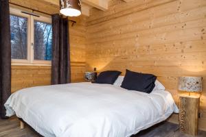a bedroom with a bed in a log cabin at Chez Gilles chalet haute cimes in Châtel
