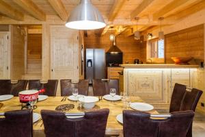 a dining room with a table and chairs and a kitchen at Chez Gilles chalet haute cimes in Châtel