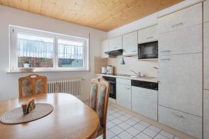 a kitchen with a wooden table and a dining room at Ferienwohnung Rehm in Bad Säckingen