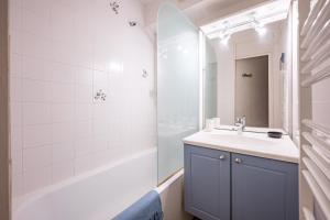 a bathroom with a sink and a tub and a mirror at Résidence Les Bergers 71 in Valloire +10 photos