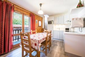 a kitchen and dining room with a table and chairs at Résidence Les Bergers 71 in Valloire