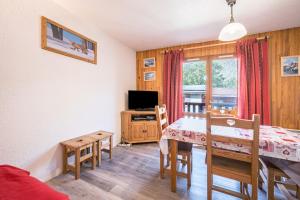 a dining room with a table and a television at Résidence Les Bergers 71 in Valloire