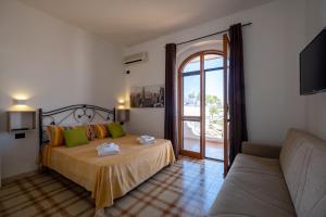 a bedroom with a bed and a couch and a window at Villa Gaudì - Sagrada in Sant'Isidoro