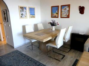 a dining room with a wooden table and white chairs at Appartement Tesoro del Mar in Torrox Costa
