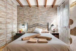 a bedroom with a large bed with two towels on it at Casa Abuela Fela in Vega de San Mateo +18 photos