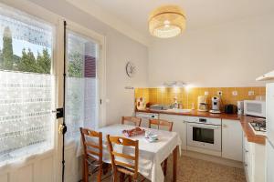 a kitchen with a table and chairs and a table and a window at Le Vigan, balcon, parking, animaux in Le Vigan