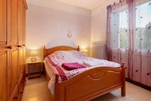 a bedroom with a wooden bed and a window at Le Vigan, balcon, parking, animaux in Le Vigan