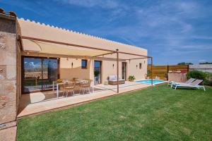 a house with a patio with a table and chairs at Son Rossinyol Nou - Ses Figueretes in Islas Baleares