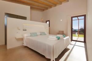 a bedroom with a white bed with towels on it at Son Rossinyol Nou - Ses Figueretes in Islas Baleares
