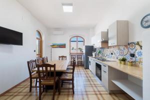 a kitchen with a wooden table and chairs in a kitchen at Villa Gaudì - Sagrada in Sant'Isidoro