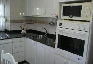 a kitchen with a sink and a microwave at Finca El Carbayal in El Campo