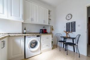 a kitchen with a washing machine and a table with chairs at Penthouse Victoria in Fuengirola