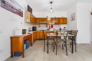 a kitchen with wooden cabinets and a table and chairs at Casa Vacanza Da Gabry in Perdaxius +22 photos