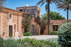 an old building with a palm tree in front of it at Son Garreta in El Palmer