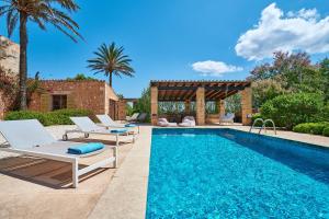 a swimming pool with chairs and a gazebo at Son Garreta in El Palmer