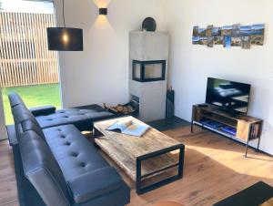 a living room with a couch and a television at Ferienhaus Riedlodge Bodensee-Obers in Guggenhausen