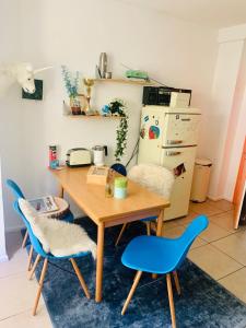 a kitchen with a wooden table and two blue chairs at Am Weinberg Kassel Gästezimmer in Kassel