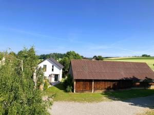 a barn and a white house in a field at Ferienhaus Riedlodge Bodensee-Obers in Guggenhausen