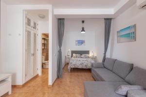 a living room with a couch and a bed at Vv Faro in Puerto de Mogán
