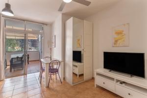 a living room with a television and a table and chairs at Vv Faro in Puerto de Mogán