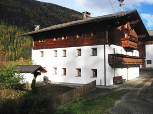 a large white building with a wooden roof at Oberhöher Apt Talblick in San Pietro +27 photos