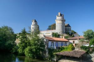 a castle with two towers on a hill next to a river at Gîte 4 Pers L'étoile De Mer in Apremont