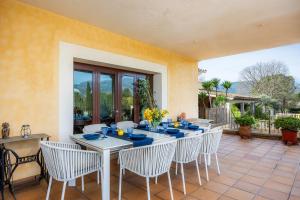 a dining table and chairs on a patio at El Olivar in El Port de la Selva