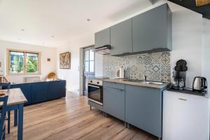 a kitchen with stainless steel appliances and a wooden floor at Gîte Ty Berniques in Pléneuf-Val-André