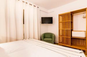a bedroom with a bed and a green chair at Drac Blanc 1-3 in Cala Ratjada +16 photos