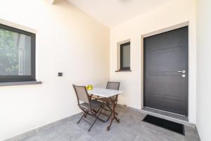 a dining room with a table and a black door at Chambre indépendante climatisée in Laroque-des-Albères