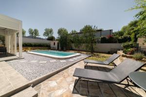 a backyard with a swimming pool and two chairs at Chambre indépendante climatisée in Laroque-des-Albères