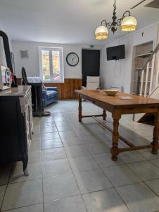 a kitchen with a wooden table in the middle of a room at Gîte chez mémé in Assieu