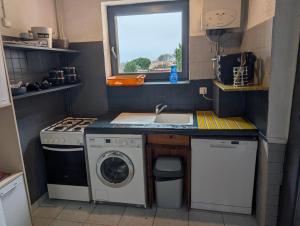 a small kitchen with a washing machine and a sink at Gîte chez mémé in Assieu +8 photos