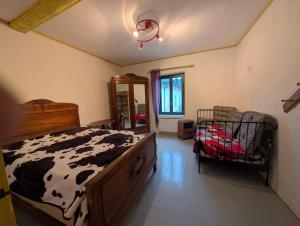 a bedroom with a cow print bed in a room at Gîte chez mémé in Assieu