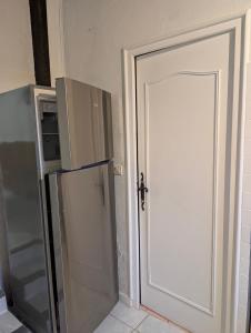 a door leading into a kitchen with a refrigerator at Gîte chez mémé in Assieu