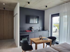 a room with a table and a kitchen with a tv at Apartment Schlossterrassen 4b in Pouch